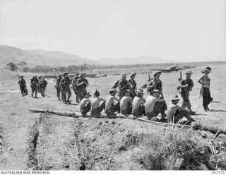 KAIAPIT, NEW GUINEA. 1943-09-25. TROOPS OF THE 2/14TH AUSTRALIAN INFANTRY BATTALION ARRIVING AT THE CAMP AREA. ENGINEERS RESTING IN THE FOREGROUND