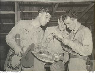 VIVIGANI, GOODENOUGH ISLAND, PAPUA. C. 1943-09. BOMBER CREW OF NO. 100 (BEAUFORT) SQUADRON RAAF IN STRIP OPERATIONS ROOM AFTER NIGHT RAID ON GASMATA, NEW BRITAIN. LEFT TO RIGHT: FLIGHT SERGEANT ..