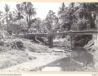 NAGADA, NEW GUINEA. 1944-09-11. A JEEP PASSING OVER A TEMPORARY BOX GIRDER BRIDGE WHILE SAPPERS OF THE 5TH FIELD COMPANY BUILD THE BRIDGE OVER THE NAGADA RIVER ON THE MADANG-ALEXISHAFEN ROAD