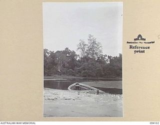 KILLETIN, NEW GUINEA, 1945-06-28. A WRECKED JAPANESE BARGE AT KILLETIN BEACH SHOWING SWAMP IN BACKGROUND