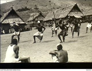 Kila Kila, New Guinea. 1943-12-25. Fly River tribesmen performing a traditional hunting dance during the Christmas celebrations at the Australian and New Guinea Administration Unit (ANGAU) Transit ..