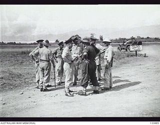 LAE, NEW GUINEA. 1943-10-01. A GROUP OF OFFICERS FROM 5TH AUSTRALIAN DIVISION TALKING NEAR A RUNWAY AT HEADQUARTERS. SHOWN: LIEUTENANT GENERAL SIR IVEN MACKAY; BRIGADIER BROADBENT; LIEUTENANT ..