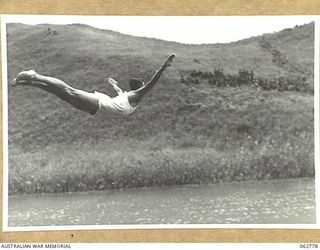 KUBA LAKE, RAMU VALLEY, NEW GUINEA. 1943-12-25. VX66633 PRIVATE N. COBBY COMPETING IN THE DIVING CONTEST AT THE CHRISTMAS CARNIVAL AND REGATTA ORGANISED BY MEMBERS OF THE 2/14TH INFANTRY BATTALION, ..