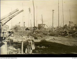 ALEXISHAFEN, NEW GUINEA. 1944-06-10. AN AREA DEVASTATED BY ALLIED BOMBING AND STRAFING WHICH IS LOCATED IN THE VICINITY OF 2/15TH FIELD AMBULANCE. IN THE FOREGROUND CAN BE SEEN A DAMAGED 75MM ..