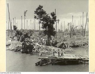ALEXISHAFEN, NEW GUINEA. 1944-04-27. MEMBERS OF THE 30TH INFANTRY BATTALION AT A BOMB DAMAGED WHARF