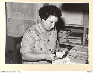 LAE, NEW GUINEA, 1945-05-23. PRIVATE O. FINUCANE, CLERK, AUSTRALIAN WOMEN'S ARMY SERVICE, WORKING AT FIRST ARMY SURVEY. AUSTRALIAN WOMEN'S ARMY SERVICE PERSONNEL ARE AT LAE TO RELEASE MEN OF ..