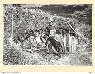 PORT MORESBY, PAPUA. 1942-07. SURE OF THEMSELVES AND THEIR MACHINE GUN, THESE AUSTRALIAN TROOPS SMILED CONFIDENTLY WHEN THE PHOTOGRAPHER ASKED THEM HOW THEY FELT ABOUT MEETING THE JAPANESE. THE ..