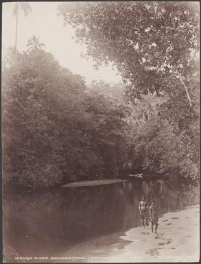 Two men standing on the banks of Wango River, Wango, Solomon Islands, 1906 / J.W. Beattie