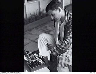 Heidelberg, Vic. 1943-10-06. Captain Dick Le Messurier, who was wounded fighting in New Guinea with the Australian Imperial Force (AIF), typing a letter home while a patient in the 115th Australian ..