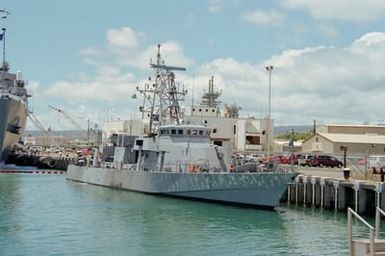 Starboard bow view of the Cyclone class patrol craft USS SQUALL (PC 7) tied up to the quay, Berth S-1, at Merry Point. Note the craft is painted in a splinter camouflage scheme. The SQUALL is taking part in Operation RIMPAC 2000