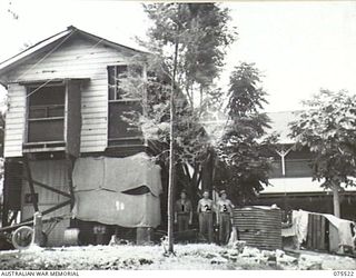 MADANG, NEW GUINEA. 1944-08-25. THIS BUILDING, FORMALLY THE POLICE MAGISTRATES RESIDENCE, IS BEING CONVERTED INTO A UNIT OF THE 2/11TH GENERAL HOSPITAL TO HOUSE THE PATHOLOGICAL, DENTAL AND ..