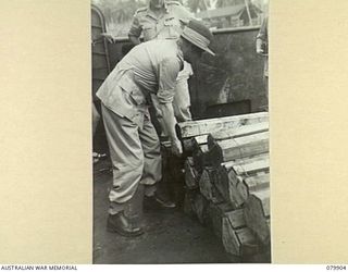 AITAPE, NEW GUINEA. 1945-03-23. LORD WAKEHURST, KCMG, GOVERNOR OF NEW SOUTH WALES (1), EXAMINING AMMUNITION ABOARD AN AMERICAN LCT (LANDING CRAFT TANK)