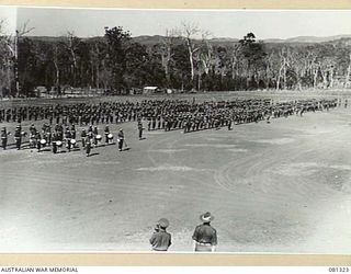 HERBERTON, QUEENSLAND, AUSTRALIA. 1944-10-11. TROOPS OF THE 2 /4TH INFANTRY BATTALION AWAIT THE ARRIVAL OF VX17 MAJOR GENERAL J.E.S. STEVENS, DSO, ED, GOC 6TH DIVISION, TO MAKE A PRESENTATION OF ..