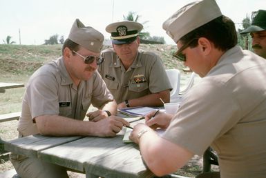 U.S. Navy officers of Mobile Inshore Undersea Warfare Unit 1519 discuss plans during inshore undersea warfare operations