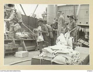 LAE, NEW GUINEA. 1944-11-02. PERSONNEL OF B COMPANY, 14/32ND INFANTRY BATTALION BEING ISSUED WITH THEIR LIFEJACKETS AS THEY BOARD THE TROOPSHIP, "CAPE ALEXANDER"