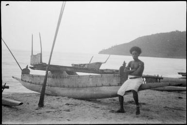 Man sitting on the prow of a beached canoe, New Guinea, ca. 1929 / Sarah Chinnery