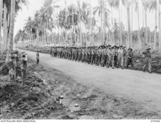 MADANG, NEW GUINEA. 1944-07-03. TROOPS OF HEADQUARTERS COMPANY, 24TH INFANTRY BATTALION GIVE "EYES RIGHT" TO THEIR COMMANDING OFFICER, VX185 LIEUTENANT COLONEL G.F. SMITH, DOS, (1) AS THEY MARCH ..