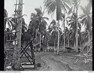 LUNGGA, GUADALCANAL, BRITISH SOLOMON ISLANDS PROTECTORATE. 1943-10-14. THE DISTRICT SUPERVISING INTELLIGENCE OFFICE BASE CAMP SHOWING THE SHOWERS AND NATIVE QUARTERS. THE BUILDING ON THE RIGHT IS ..