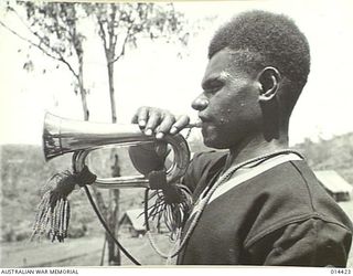 1943-03-15. NEW GUINEA. KAHAWIL, A BUGLER FROM THE ADMIRALTY ISLANDS AT A CEREMONIAL PARADE OF THE ROYAL PAPUAN CONSTABULARY SOMEWHERE IN NEW GUINEA. (NEGATIVE BY BOTTOMLEY & BROWN)
