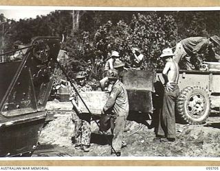 NASSAU BAY, NEW GUINEA. 1943-08-16. TROOPS OF "D" COMPANY, 542ND ENGINEERING BOAT AND SHORE REGIMENT UNITED STATES FORCES, LOADING BARGES. IN THE FOREGROUND ARE:- 13065556 KERMIT MCCLANAHAN (LEFT); ..