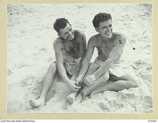KELANOA, NEW GUINEA, 1944-02-20. SERGEANT GEORGE DOSSEY, OF CALIFORNIA (1), AND CORPORAL CHESTER KILMECK, OF PENNSYLVANIA (2), MEMBERS OF THE UNITED STATES ARMY, LAUGHINGLY UNTANGLE THEMSELVES ..