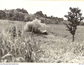 GUSIKA, NEW GUINEA. 1944-03-15. A CUPOLA FITTED BY MEMBERS OF THE 1ST TANK BATTALION TO A MATILDA TANK BODY, PICTURED UNDERGOING VULNERABILITY TESTS. THE BURSTS OF HIGH EXPLOSIVE ARE FROM A 3" ..