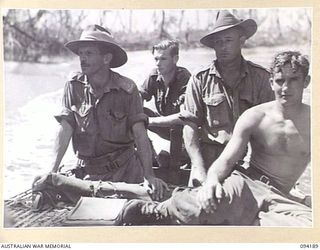 WEWAK AREA, NEW GUINEA. 1945-07-18. PRIVATE A.W. LAWLER OF 104 CASUALTY CLEARING STATION (2) AND MEMBERS OF 2/22 FIELD PARK COMPANY, ROYAL AUSTRALIAN ENGINEERS, ABOARD A MOTOR LAUNCH ON URFIP CREEK ..