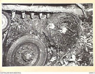 TOROKINA AREA, BOUGAINVILLE. 1945-07-28. THE REAR PORTION OF THE TRACK OF AN M24 GENERAL CHAFFEE LIGHT TANK WHICH IS CLOGGED WITH VINES DURING TESTS CONDUCTED FOR THE WAR OFFICE