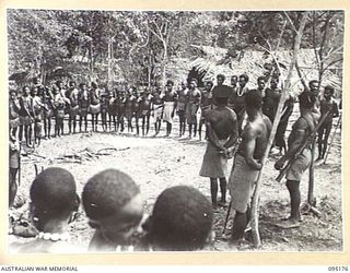 KIARIVU, NEW GUINEA, 1945-08-11. NATIVE REFUGEES LINED UP FOR INSPECTION BY NATIVE POLICE EMPLOYED BY AUSTRALIAN NEW GUINEA ADMINISTRATIVE UNIT . THEY WERE RELEASED FROM VILLAGES PREVIOUSLY ..