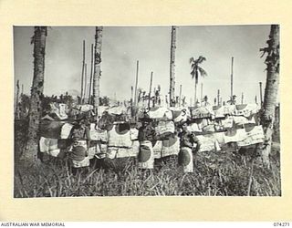 HANSA BAY, NEW GUINEA. 1944-06-22. THREE SOUVENIR HUNTERS OF HEADQUARTERS, 8TH INFANTRY BRIGADE, PROUDLY DISPLAYING THEIR LARGE COLLECTION OF JAPANESE FLAGS CAPTURED IN THE AREA. THEY ARE:- WX10542 ..