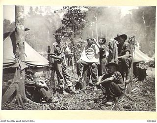 WONGINARA MISSION, NEW GUINEA. 1945-04-07. CORPORAL N WEBB, 2/3 INFANTRY BATTALION (3), HAVING HIS HAIR CUT BY PRIVATE W WELLS (4). THE UNIT IS IN THE TORRICELLI MOUNTAINS INLAND FROM DAGUA. ..