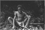 Boy with backpack sits on small bridge