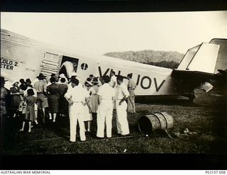 Salamaua, New Guinea. 1941-12. A crowd stands on the airfield watching women and children board the tri-motor Junkers 31 aircraft VH-UOV owned by Bulol Gold Dredging Ltd. This aircraft evacuated ..