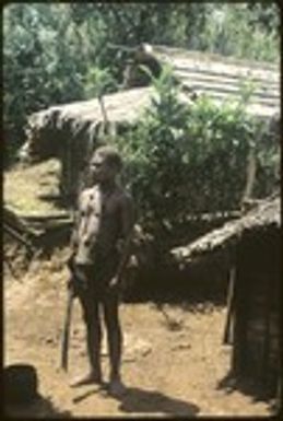 Man standing in front of building with machete