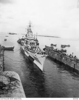 MANUS, ADMIRALTY ISLANDS. 1944-10. STARBOARD BOW VIEW OF THE CRUISER USS CANBERRA (CA-70) MOVING SLOWLY INTO AN ADVANCED BASE SECTIONAL DOCK. THERE SHE IS TO BE PREPARED FOR THE VOYAGE TO A HOME ..