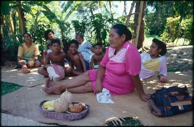 Group sitting on mats under trees