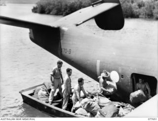 JACQUINOT BAY, NEW BRITAIN. 1944-12-19. PERSONNEL OF THE BASE POST OFFICE, GROUP 848 RAAF UNLOADING CHRISTMAS MAIL FROM THE MARTIN "MARINER" FLYING BOAT INTO A MOTOR LAUNCH