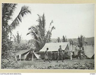 JACQUINOT BAY, NEW BRITAIN. 1944-11-07. THE CAMP AREA OF THE 6TH INFANTRY BRIGADE SIGNALS ON A HILL IN THE WUNUNG PLANTATION OVERLOOKING THE BAY. IDENTIFIED PERSONNEL ARE: TX14279 CORPORAL G.H. ..