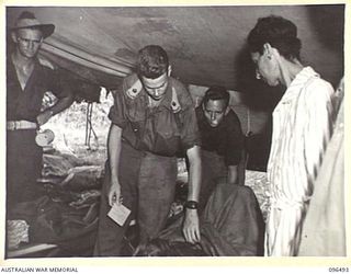 RABAUL, NEW BRITAIN, 1945-09-13. MAJOR A.J. BARNETT, MEDICAL OFFICER, 4 FIELD AMBULANCE, EXAMINES AN INDIAN SERVICEMAN PATIENT. THE MAN WAS ONE OF THOSE LIBERATED FROM THE JAPANESE FOLLOWING THE ..