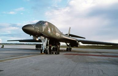 Flight line personnel stand beneath a B-1B aircraft parked on the flight line during Exercise DISTANT MARINER