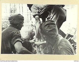 TSIMBA AREA, BOUGAINVILLE ISLAND. 1945-02-13. TROOPS OF THE MORTAR DETACHMENT, 31/51ST INFANTRY BATTALION OPERATING THE UNIT FERRY ACROSS THE GENGA RIVER. THE FERRY CONSISTS OF A COLLAPSIBLE BOAT ..