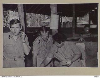 LAE, NEW GUINEA, 1945-05-20. PRIVATE M. MALONEY AWAS (3), SORTING MAIL AT THE ORDERLY ROOM, HQ AUSTRALIAN ARMY CANTEENS SERVICE. IDENTIFIED PERSONNEL ARE:- WARRANT OFFICER 1 D.A. VAUGHAN (1); PTE ..