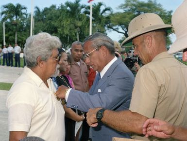 Governor Ricardo J. Bordallo of Guam pins a medal on one of the Asiatic-Pacific Campaign Medal and the World War II Victory Medal during a Veterans Day memorial service at Skinner Plaza. Colonel J. Karl Miller looks on