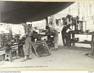 ALEXISHAFEN, NEW GUINEA. 1944-09-13. NX121422 WARRANT OFFICER II, K.A. O'ROURKE (1) NX130518 CRAFTSMAN J. SUTHERLAND (2) AND NX156878 CRAFTSMAN W.J. DUNN (3) WORKING IN THE MACHINE AND FITTING SHOP ..