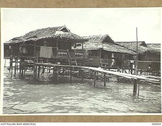 PA PA, PAPUA. 1943-12-02. GENERAL VIEW OF SOME OF THE NATIVE HUTS IN THE AREA. SOME LIKE THESE ARE BUILT OUT IN THE WATER WHILE OTHERS ARE BUILT ON THE SHORE