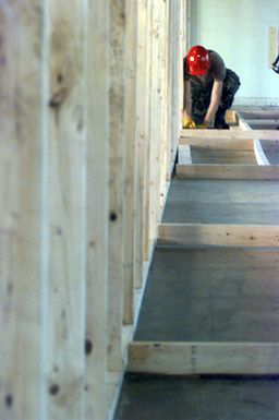 A member of the Red Horse Air National Guard, Rickenbacker Air National Guard Base, Columbus, Ohio, nails together wall studs as part of the conversion of old dorms at Andersen Air Force Base, Guam, into temporary housing for victims of Typhoon Paka