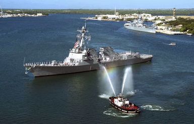 A commercial tugboat (foreground) provides a water salute, as the US Navy (USN) Arleigh Burke Class (Flight IIA): Guided Missile Destroyer (Aegis), USS CHUNG-HOON (DDG 93), arrives in harbor at its new home port at Pearl Harbor, Hawaii (HI). The ship is named in honor of Rear Admiral Gordon Paie'a Chung-Hoon, who was born and raised in Hawaii and awarded the Navy Cross and Silver Star for gallantry as Commanding Officer of USS SIGBEE (DD-502) during the Battle of Okinawa. The USS MISSOURI (BB 63) Memorial is visible in the background