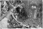 Young boy tending fire with skulls in background