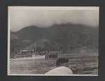 MV Elevala with passengers, village? and mountain in background, Papua New Guinea, c1945 to 1952