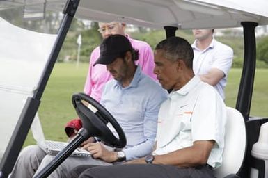 Barack Obama confers with Robert Baker after he plays golf in Kaneohe Bay, Hawaii, December 24, 2014